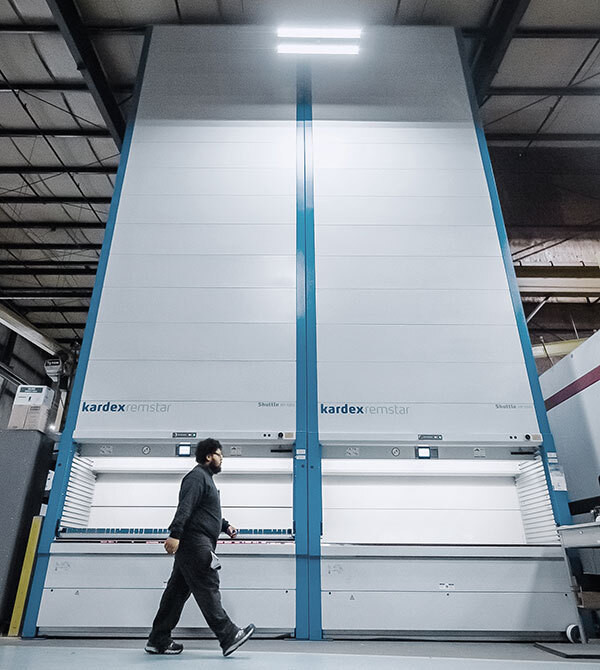 Employee walks in front of two Kardex vertical lift modules
