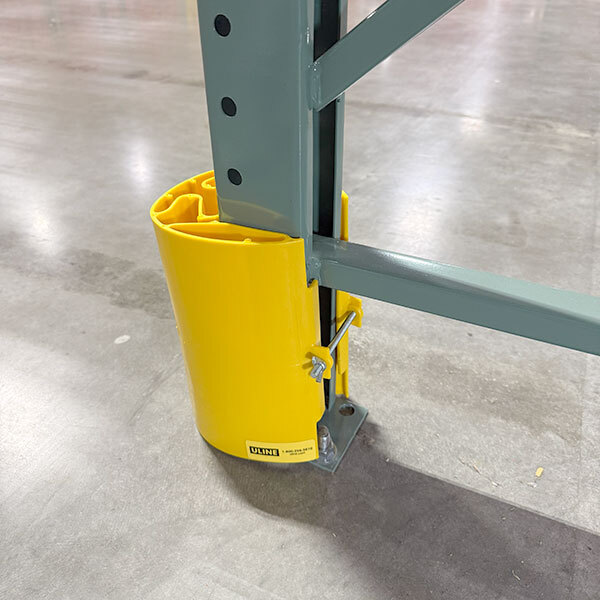 Yellow plastic column guard protecting pallet rack upright