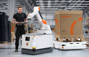 A warehouse employee interacts with autonomous mobile robots