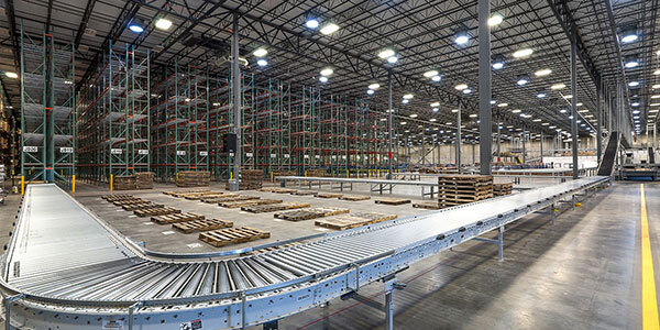 A line of conveyor with pallet rack system in the background