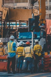 Four employees observe machine from a save distance.