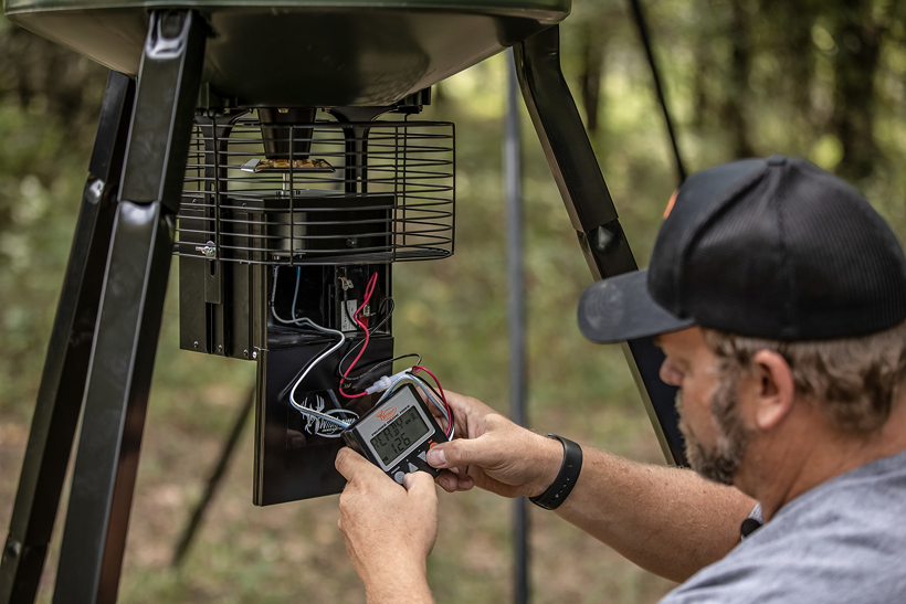 Adjusting the timer and motor on a tripod deer feeder