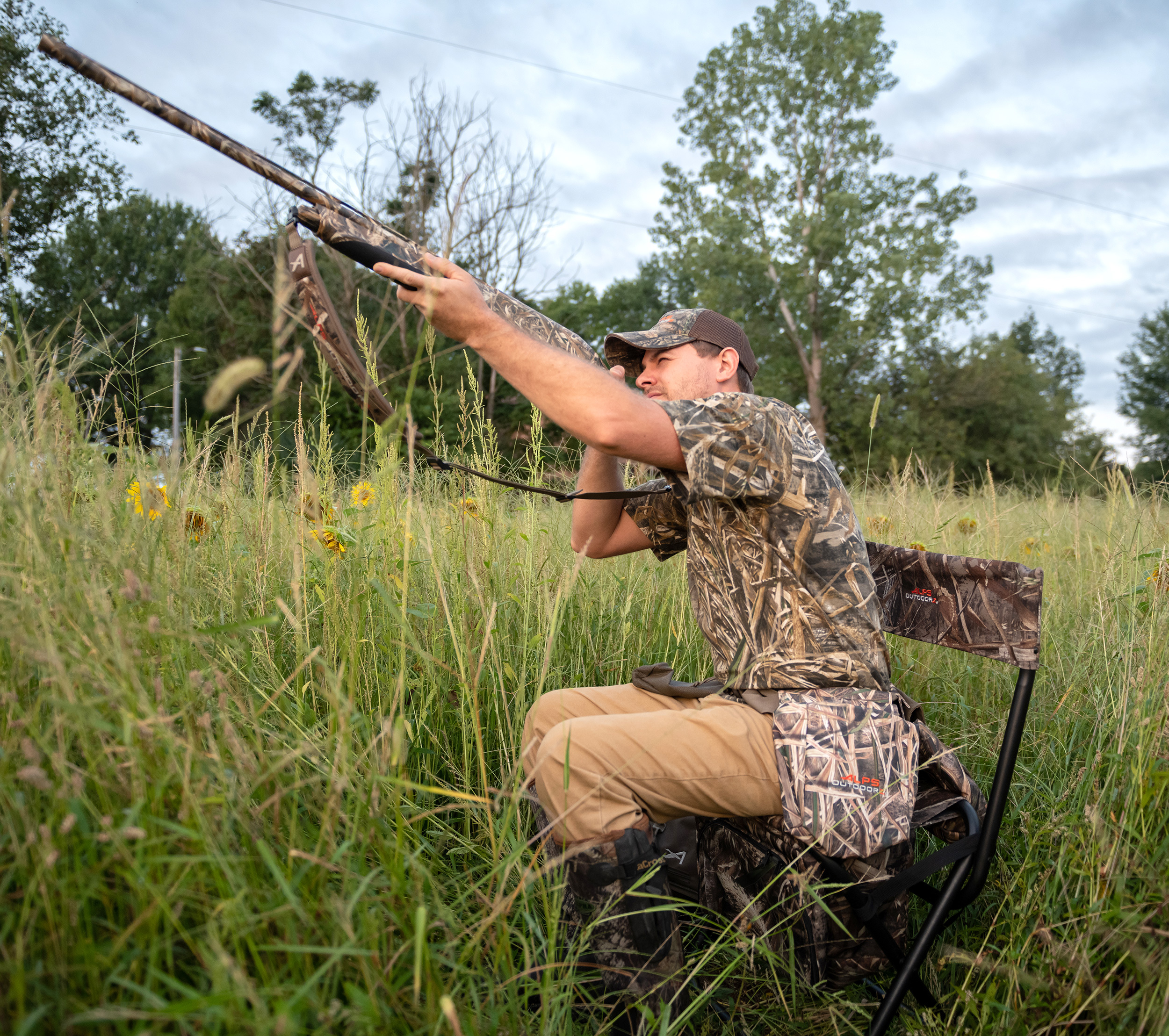 Dove hunter swinging on a bird from an ALPS OutdoorZ field chair in a September sunflower field