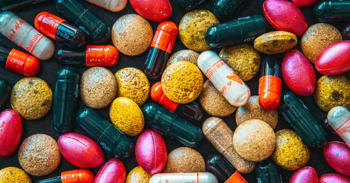 Colourful assortment of supplement capsules representing the top research-informed fertility supplements.