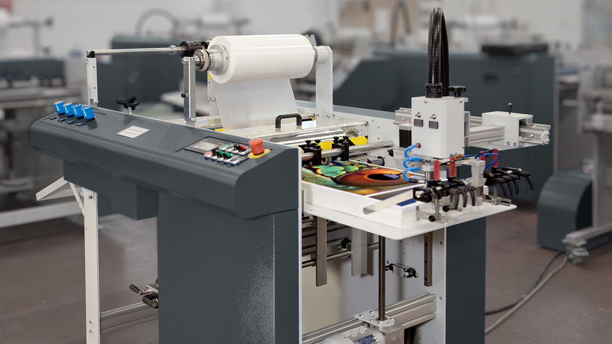 ZFP L100 PB double sided laminator with film loaded and laminated prints on the delivery tray