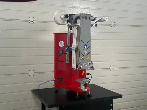 InnoPrinter MK1 roll-to-roll semi-automatic heat press in red with loaded transfer roll mounted on a worktable