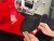 Operator loading a black baseball cap onto the InnoPrinter MK-CAPS curved platen for fast roll-to-roll cap decorating