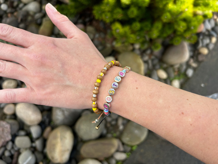 Here, the I Heart FosterClub friendship bracelet is paired with our Wood You Yellow friendship bracelet. It's a great pairing to show strong support for FosterClub and children who experience foster care!