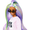 Her long hair is mermaid-inspired and styled with rainbow colors in an updo for a trendy look.​​