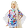 She showcases her confident style in a bright, floral-print top, matching ruffled denim shorts, a translucent flower-power poncho and white ankle boots.