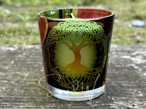 Tree of Life Printed Glass Candle Holder for votive candles shown on a rock with a candle inside for demonstration, decorative glass candle holder with Celtic-inspired design, colorful printed glass votive cup, candle not included.