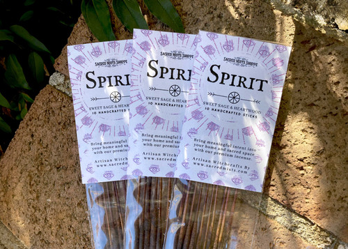 Three packs of spirit elemental handmade incense lie on brickwork in filtered sunlight