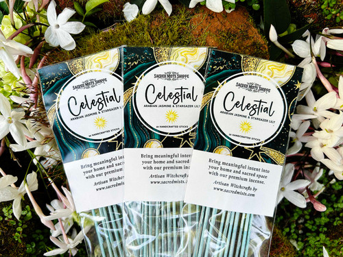 Three packs of Celestial Premium Handmade Incense lying on a bed of flowers and brick. Fragrance notes for this incense are Arabian jasmine, stargazer lily, and Himalayan cedar.