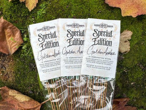 Three packs of Golden Apples special edition premium incense featuring honeygold apple and immortelle, displayed on lush greenery with autumn leaves, evoking mythic abundance and sacred harvest energy