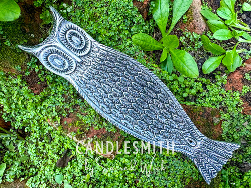 One Moonlit Owl Silver Incense Burner rests on a bed of greneery shown from above and angled to the left to show the overall length and design.