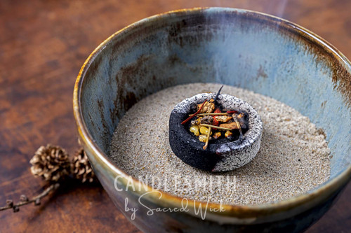 A bowl of incense sand shown from above with a charcoal block and resin burning displaying one of the many uses.