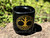 Black ceramic chime and mini taper candle holder with gold tree of life printed sitting on a rock. The view is slightly above to see the inside edge.