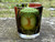 Tree of Life Printed Glass Candle Holder for votive candles shown on a rock with a candle inside for demonstration, decorative glass candle holder with Celtic-inspired design, colorful printed glass votive cup, candle not included.