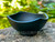 cast iron bowl with wavy edges sitting on a rock