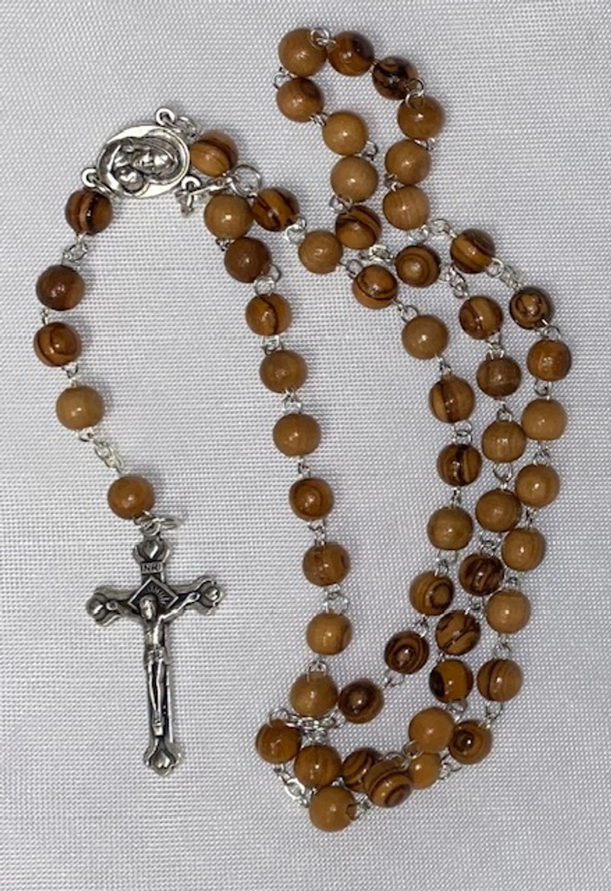 Olive wood round bead rosary with soil from the Holy Land center piece (made by Christians in the Holy Land) Olive wood round bead rosary with soil from the Holy Land center piece (made by Christians in the Holy Land)