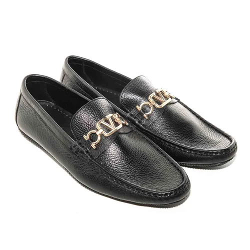 Side profile of black leather driving loafer showing metal V logo detail