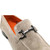 Close-up of polished metal bit detail on bone suede loafer