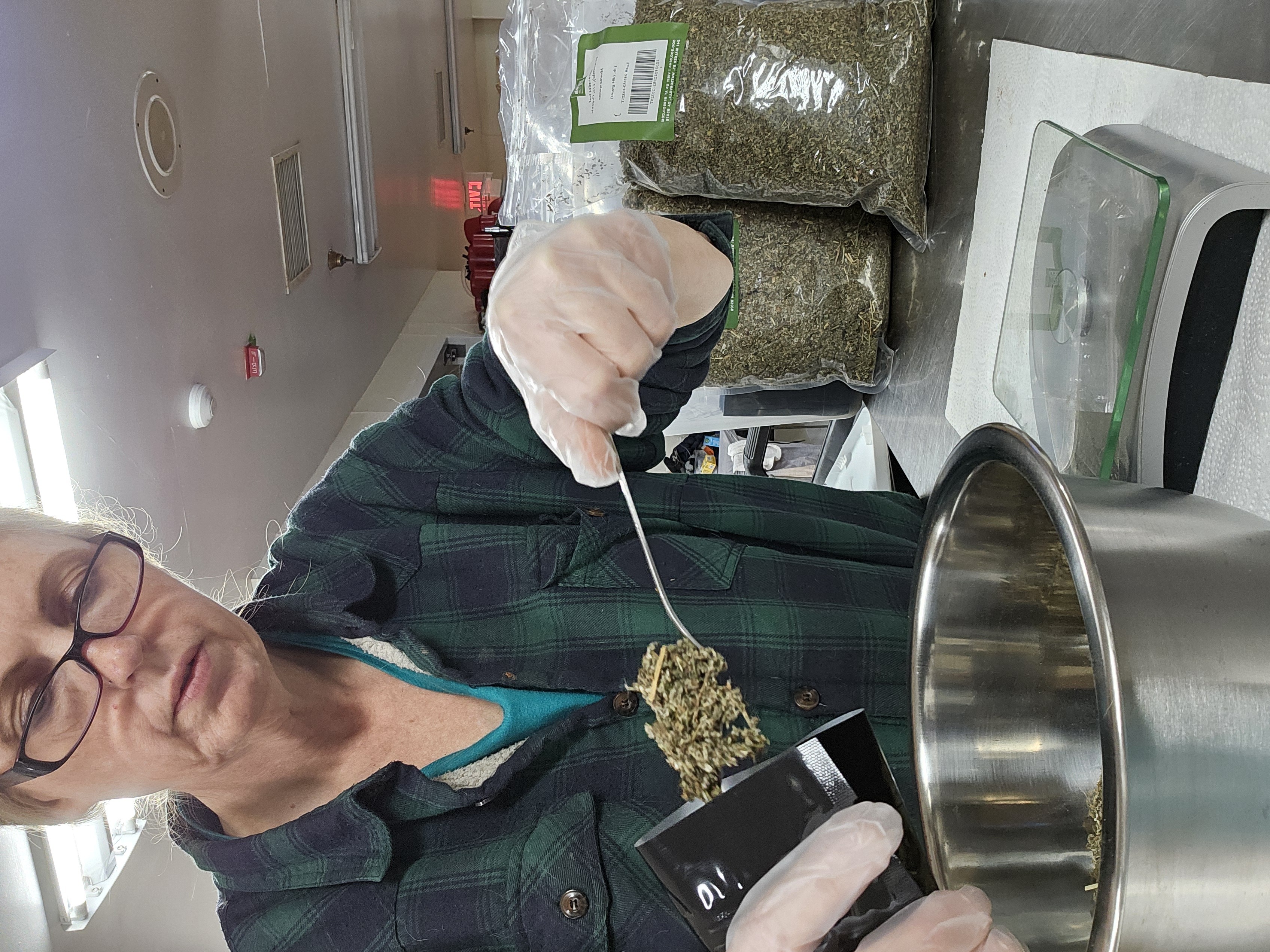 Bonnie Landsee measuring and blending herbal tea ingredients