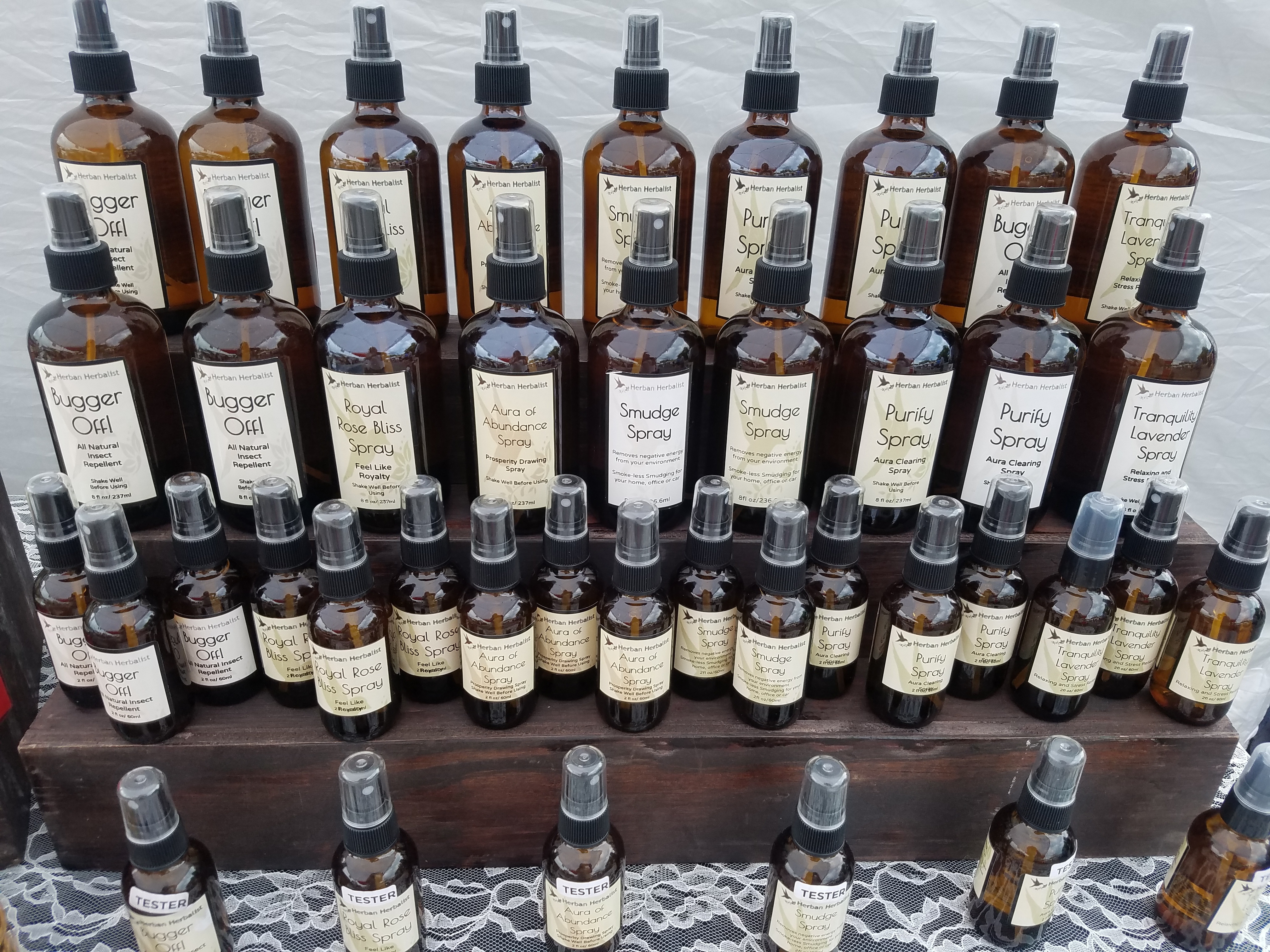 Herban Herbalist aromatherapy and smudge spray display at a market