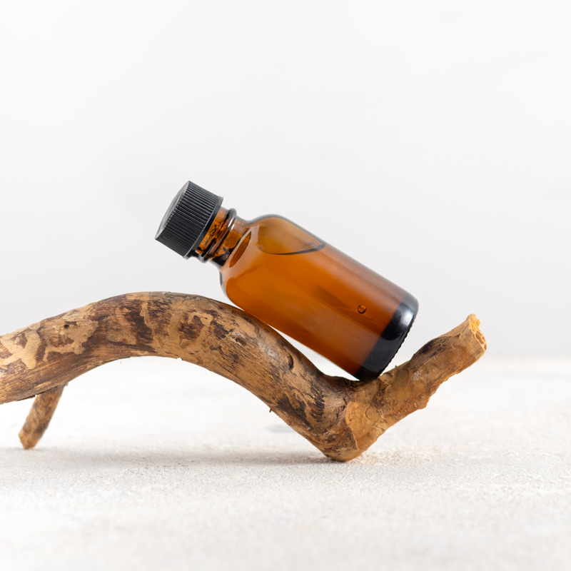 Essential oil sample in an amber bottle with black top