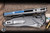Microtech Socom Elite RAM-LOK Manual Titanium Blue Accents 4" M390 Clip Point Cracked Ice Finish 160RL-CPCIINLBLTIPR