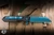 Heretic Knives Jinn Button Lock Manual Flipper Knife Black Carbon Fiber 3" MagnaCut Wharncliffe Metallic Teal H213-MT-CF