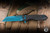 Heretic Knives Jinn Button Lock Manual Flipper Knife Black Carbon Fiber 3" MagnaCut Wharncliffe Metallic Teal H213-MT-CF