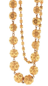 Close-up view highlighting the dimensional construction of the graduated 22K yellow gold beads, including raised circular motifs, recessed geometric sections, textured centers, and connecting gold links.