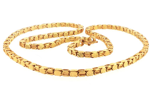 Full laid-down presentation of the 70-gram 22K yellow gold necklace, showing the continuous intricate link pattern across its 28-inch length. Alternating diamond-cut geometric and ribbed open links create a bold, substantial design with detailed texture throughout.