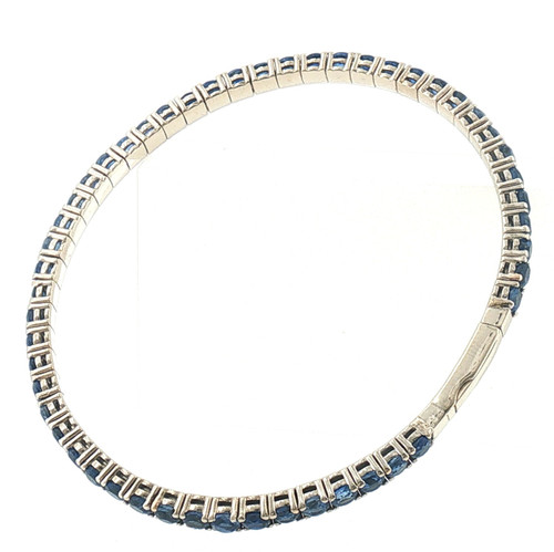 Full top view of a 14K white gold tennis bracelet featuring a continuous row of deep blue round sapphires with a secure integrated clasp.