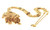 Detailed angled view of the ornate yellow gold beaded necklace showcasing its large decorative pendant, intricate granulated and filigree-inspired gold work, colorful red, green and dark accents, dangling gold beads, and elaborate tassel-style drops. The richly textured necklace chain features decorative beads and geometric stations throughout.