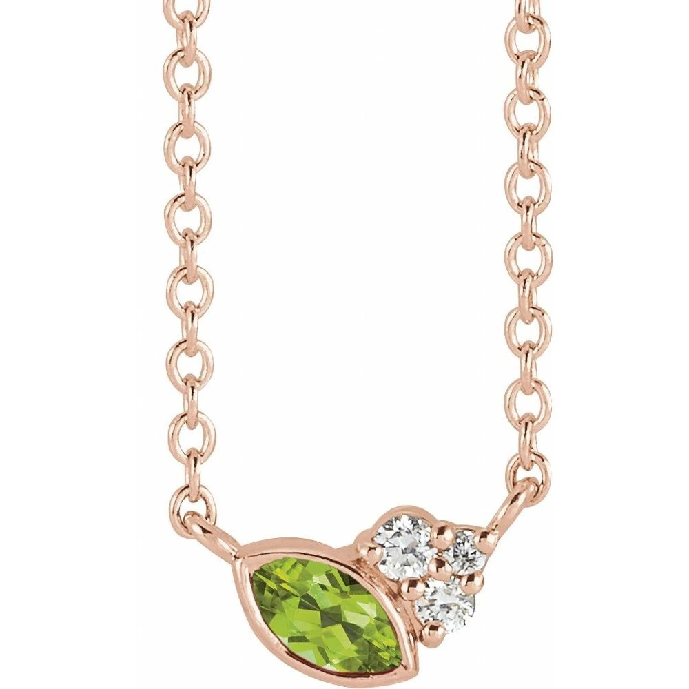 Marquise-cut peridot bezel-set beside a round diamond cluster on a 14K rose gold cable chain necklace