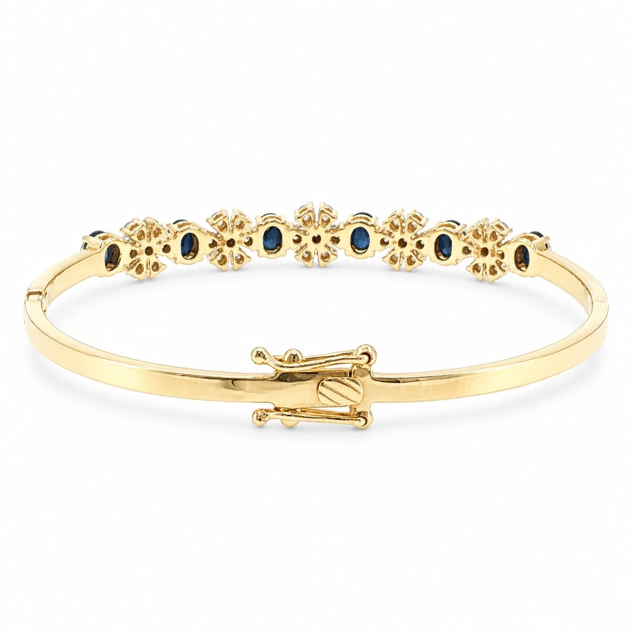 Reverse of an 18K yellow gold sapphire floral cluster bangle showing the open gallery and figure-eight safety clasp