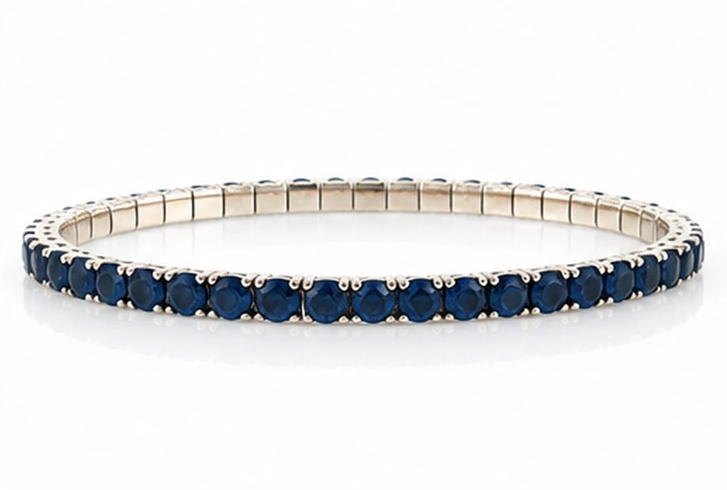 Deep blue sapphire line bracelet in 14K white gold, a continuous row of prong-set round sapphires