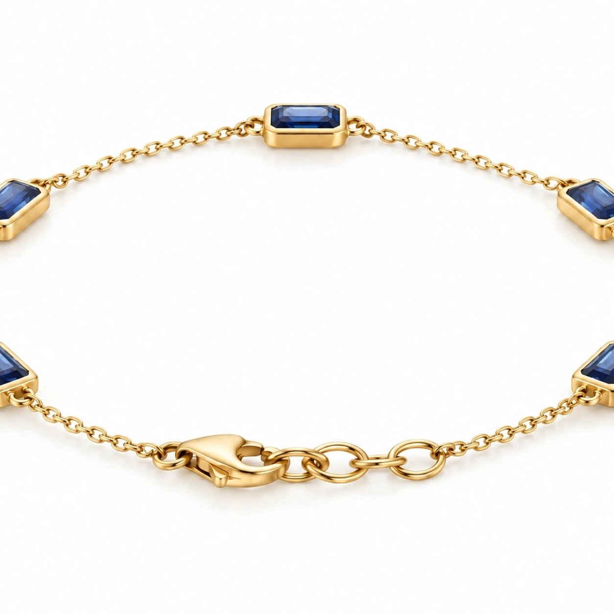Deep blue sapphire station chain bracelet in 14K yellow gold with five bezel-set emerald-cut sapphires