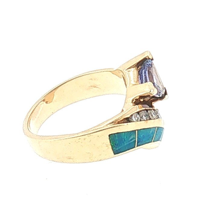 Side profile of the trillion tanzanite, opal inlay and diamond cocktail ring in 14K yellow gold