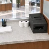 Epson TM H6000VI style printer with thermal paper rolls at a bank teller station