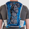 Close up of man wearing Ultimate Direction Mountain Vest 5.0, rear view, with jacket attached to pack with bungee