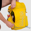 Close up of man zipping side pocket of Ultimate Direction Fastpack 20