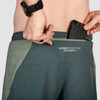 Close up of Ultimate Direction Men's Stratus Short, showing man putting phone in pocket