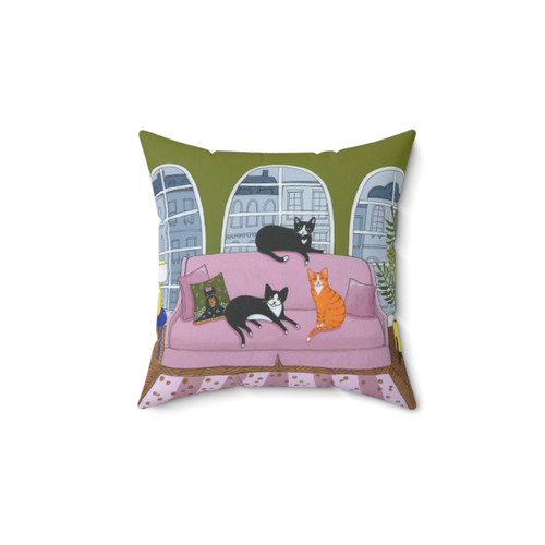 Decorative cat pillow featuring cats on a pink sofa