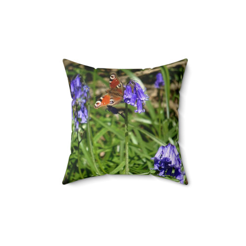 Peaceful woodland butterfly pillow featuring a peacock butterfly and bluebells