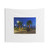 Landscape tapestry featuring a park scene with lights, water, and sculptures