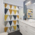 Geometric pattern shower curtains with mustard, blue, and grey triangles