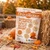 Drizzilicious Pumpkin Spice Bites bag in a fall setting with pumpkins